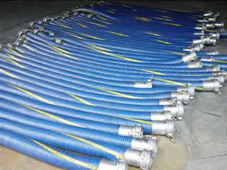 Many straight chemical marine composite hoses are on the floor.