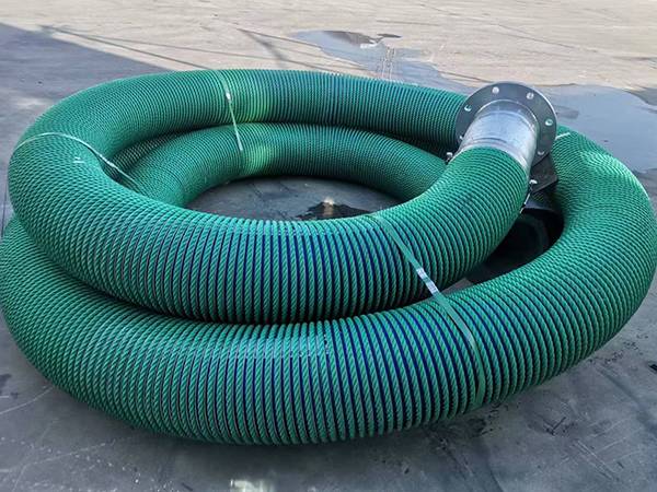 Composite hose with green nylon cover on the floor