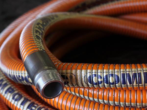 A roll of orange high temperature composite hose on the ground.